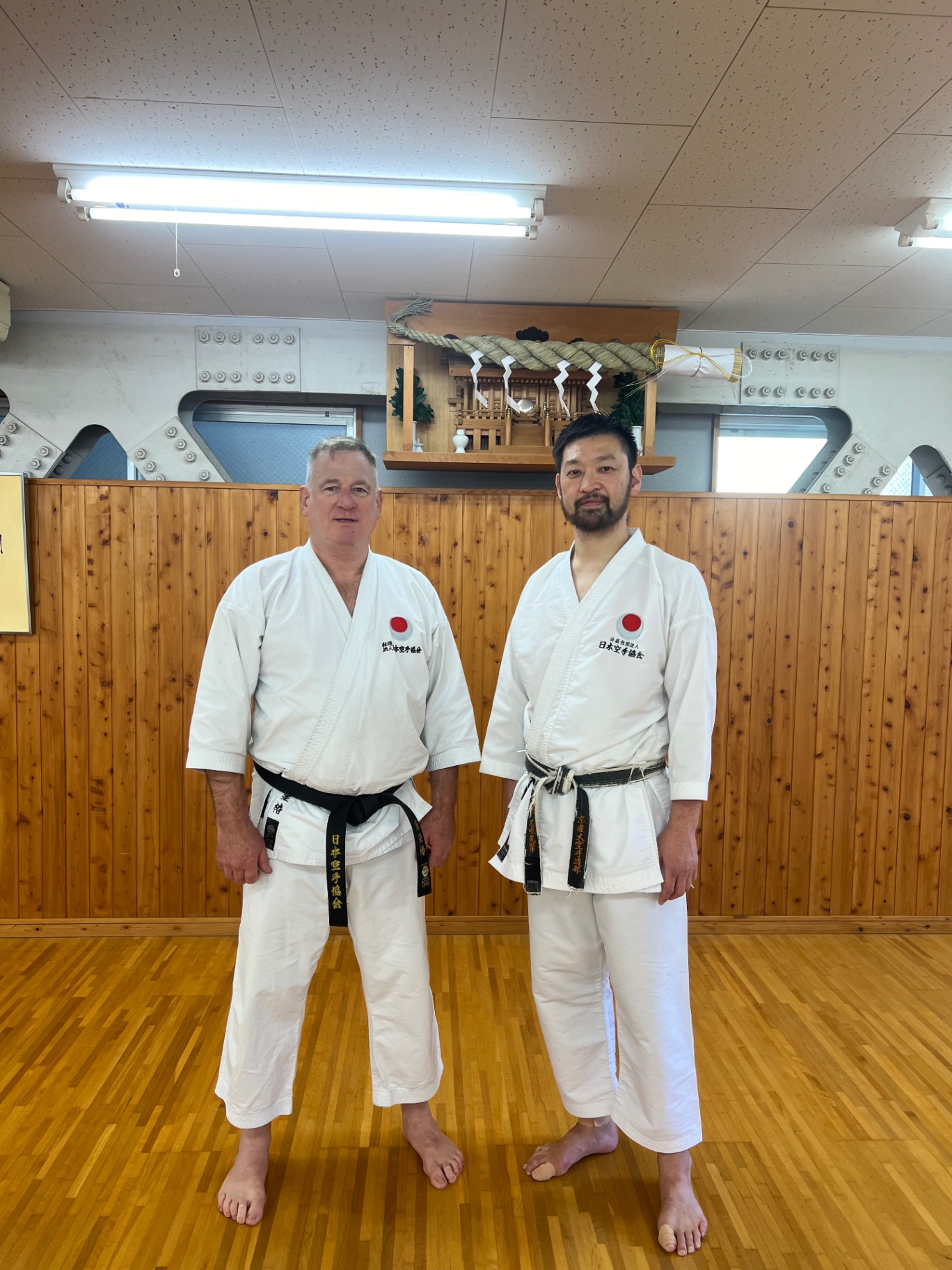 Mit japanischem Sensei im Gi vor dem Kamidana im Dojo