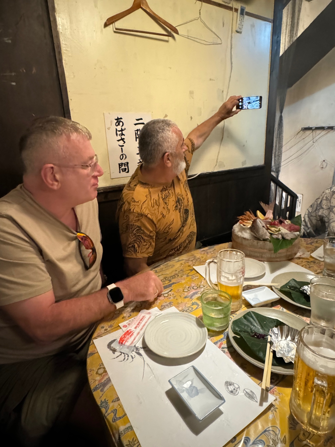 Tisch in einer Izakaya in Okinawa mit großer Sashimi-Platte und Bier