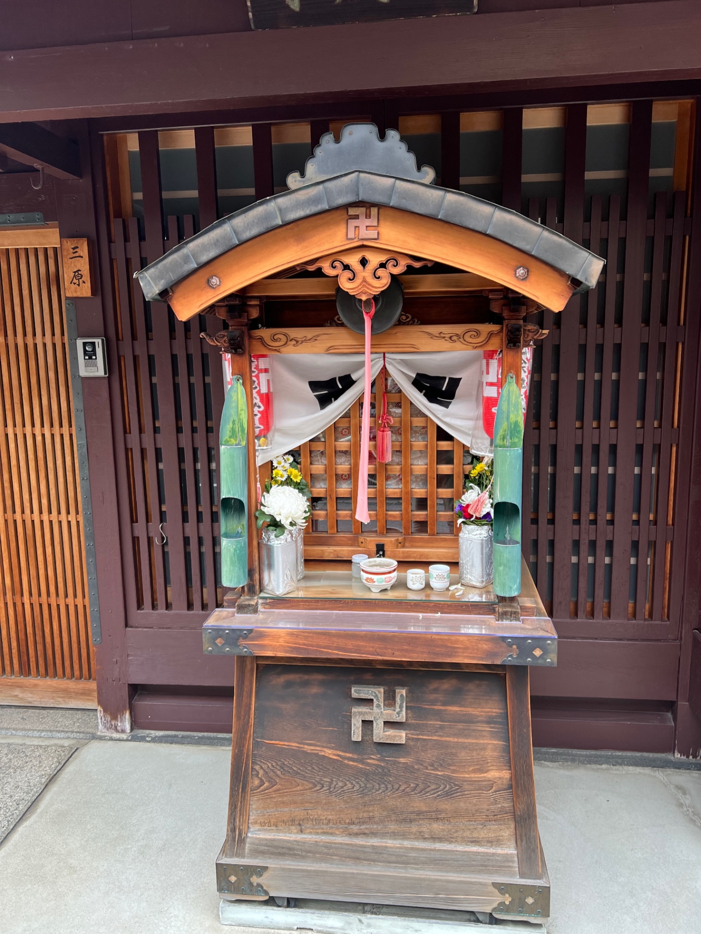 Kleiner buddhistischer Hausaltar vor einer traditionellen Holzfassade in Kyoto