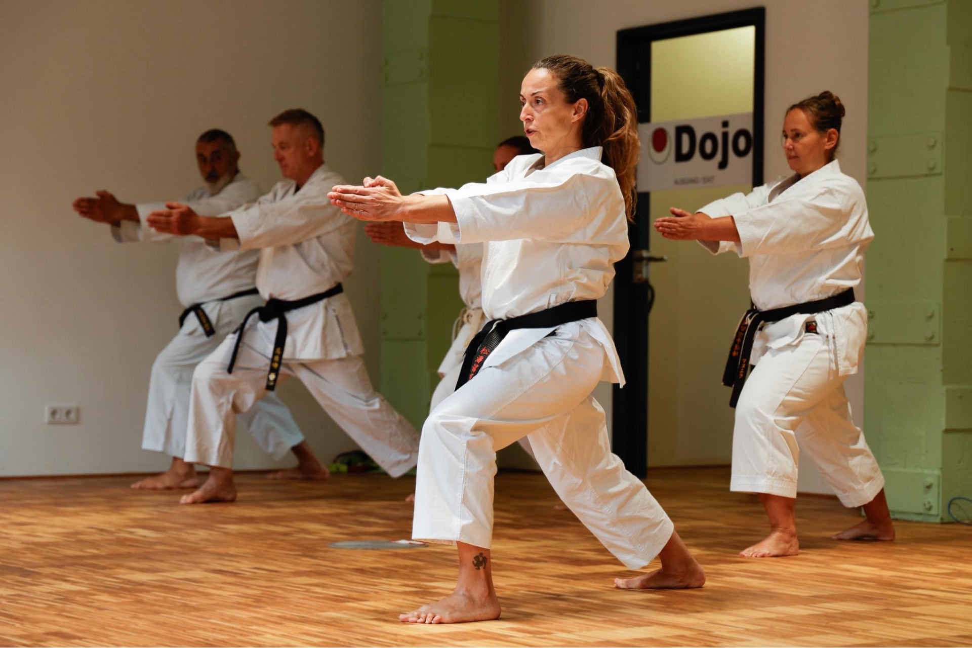 Kata-Training in Reihe vor dem Dojo-Schild