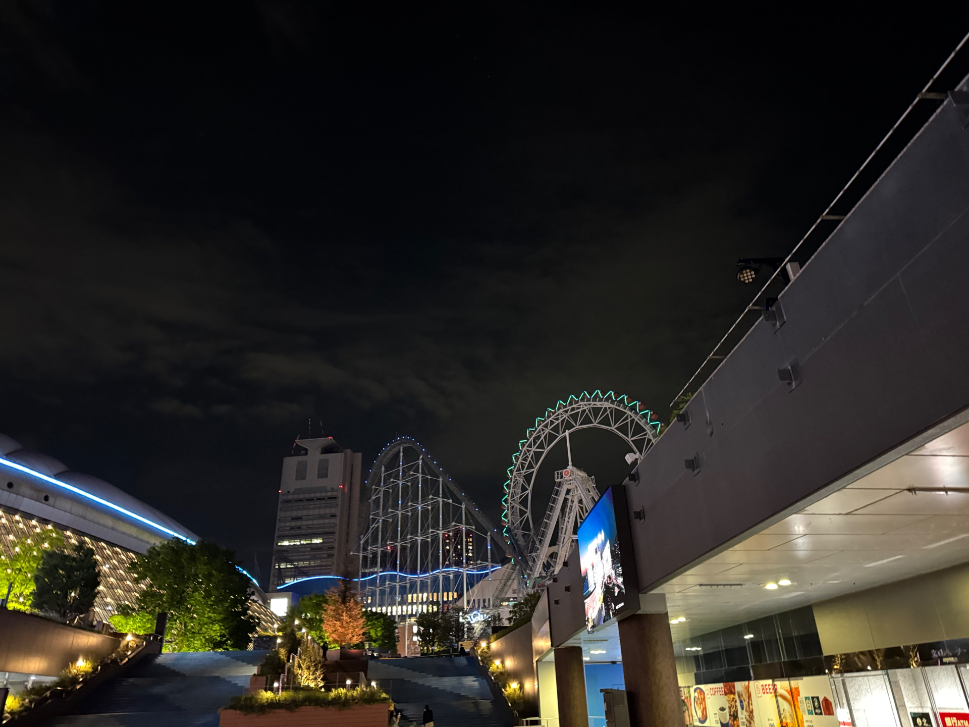 Beleuchtetes Riesenrad und Achterbahn in Tokio bei Nacht