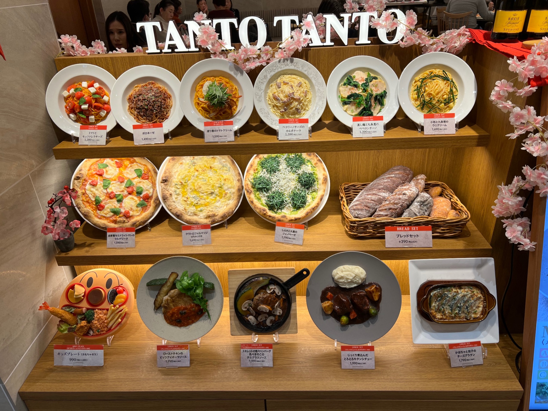 Schaufenster des Tanto-Tanto-Restaurants mit Pasta-, Pizza- und Hauptgericht-Modellen